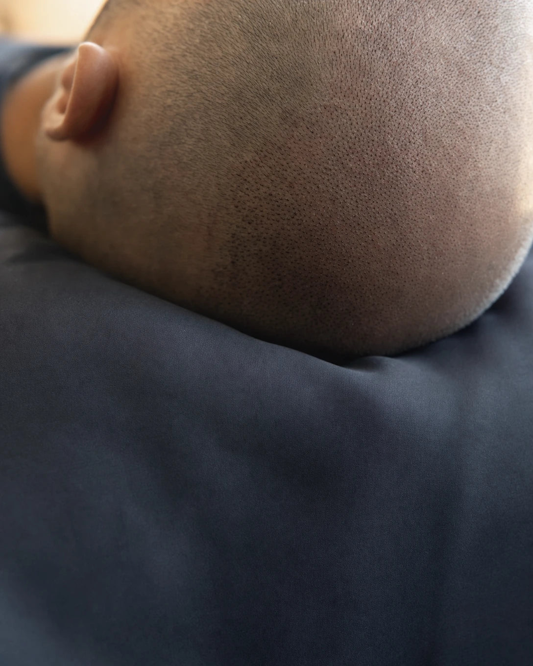Hair transplant recovery scalp resting on smooth graphite silk pillowcase — reduces graft friction